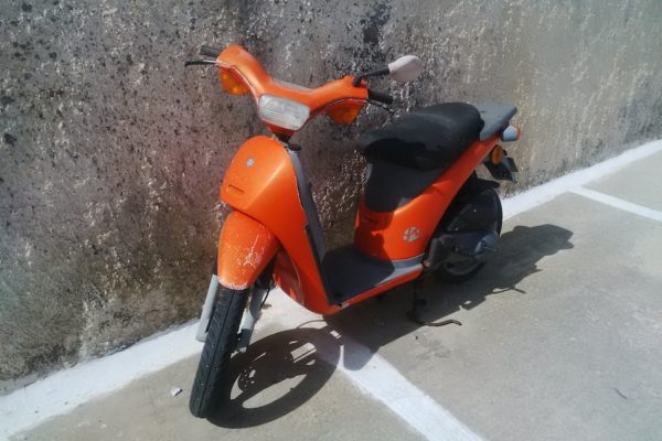 Santorini: orange scooter in the traditional village of Megalochori